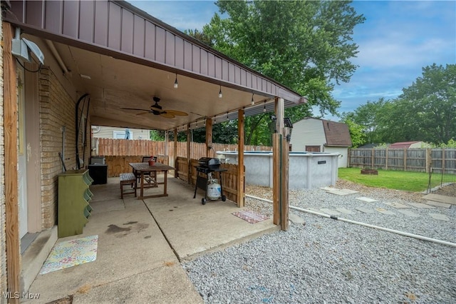1291 Woodhurst Dr, Austintown, OH 44515 - fenced backyard with ceiling fan, outdoor dining space, a patio area, and a grill