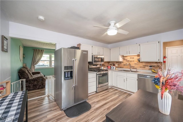 1291 Woodhurst Dr, Austintown, OH 44515 - kitchen with stainless steel appliances, light wood-type flooring, a ceiling fan, and white cabinetry