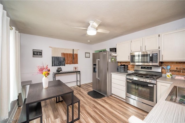 1291 Woodhurst Dr, Austintown, OH 44515 - kitchen featuring appliances with stainless steel finishes, a ceiling fan, decorative backsplash, and light countertops