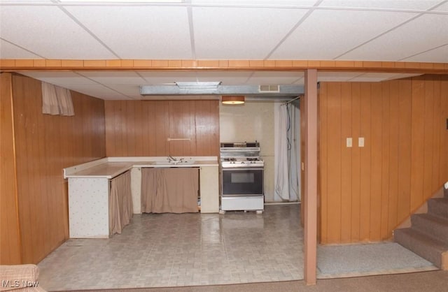 51 N Navarre Ave, Youngstown, OH 44515 - kitchen with gas range gas stove, wooden walls, a paneled ceiling, and light flooring