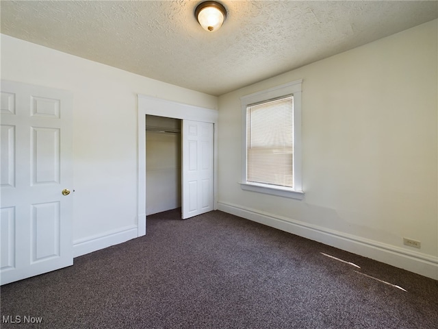 237 E Thornton St, Akron, OH 44311 - unfurnished bedroom featuring dark carpet, a closet, and a textured ceiling