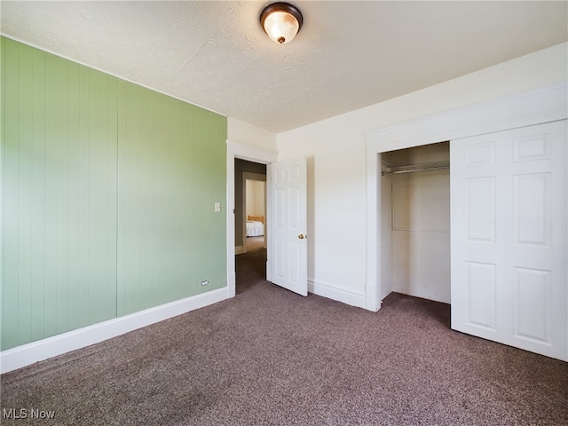 237 E Thornton St, Akron, OH 44311 - unfurnished bedroom featuring dark carpet, a closet, and a textured ceiling
