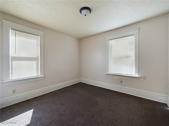 237 E Thornton St, Akron, OH 44311 - unfurnished room with dark colored carpet, healthy amount of natural light, and a textured ceiling