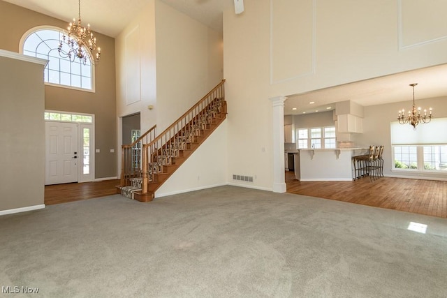 415 Cascade Ct, Avon Lake, OH 44012 - foyer featuring carpet flooring, a chandelier, a high ceiling, stairs, and wood finished floors