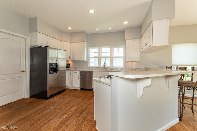 415 Cascade Ct, Avon Lake, OH 44012 - kitchen featuring stainless steel appliances, a peninsula, healthy amount of natural light, a kitchen bar, and recessed lighting
