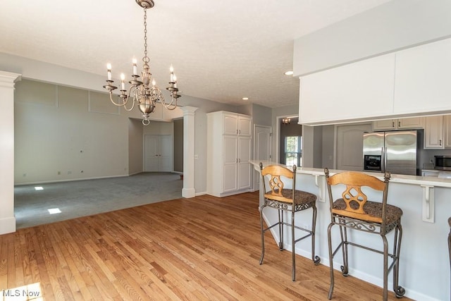 415 Cascade Ct, Avon Lake, OH 44012 - kitchen featuring appliances with stainless steel finishes, a breakfast bar, light countertops, and light wood-style floors
