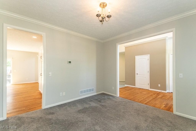415 Cascade Ct, Avon Lake, OH 44012 - empty room featuring carpet, a chandelier, ornamental molding, wood finished floors, and a textured ceiling