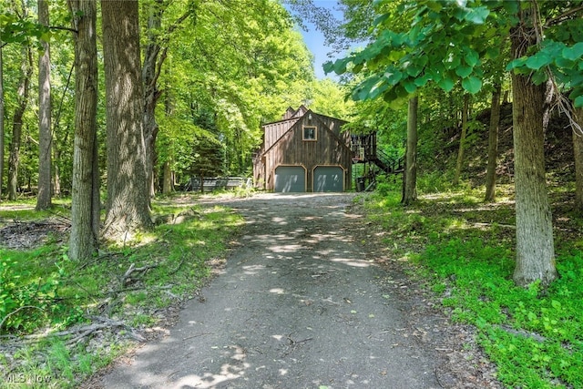 1915 Claus Rd, Vermilion, OH 44089 - view of front of house with driveway, a garage, and a view of trees