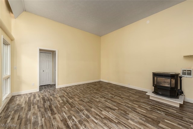 1915 Claus Rd, Vermilion, OH 44089 - unfurnished living room featuring a wood stove, dark wood-style flooring, and high vaulted ceiling