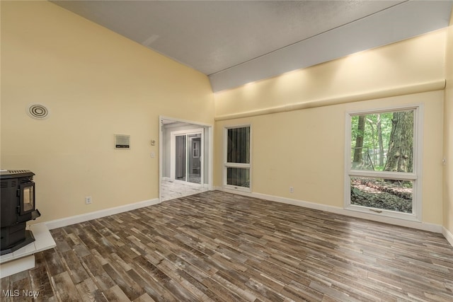 1915 Claus Rd, Vermilion, OH 44089 - unfurnished living room with a wood stove, wood finished floors, and a high ceiling