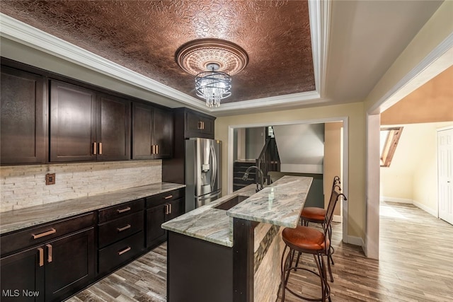 1915 Claus Rd, Vermilion, OH 44089 - kitchen with stainless steel fridge, a kitchen breakfast bar, a tray ceiling, and wood finished floors