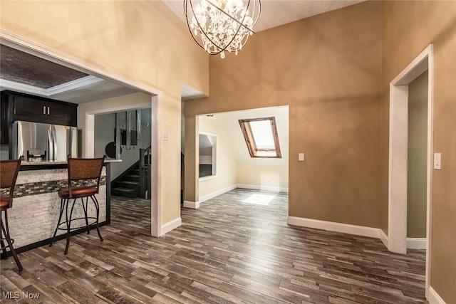1915 Claus Rd, Vermilion, OH 44089 - kitchen with stainless steel fridge with ice dispenser, dark wood-type flooring, a chandelier, dark cabinetry, and a breakfast bar