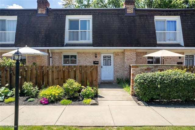 6480 State Rd Unit F7, Parma, OH 44134 - townhome / multi-family property featuring mansard roof, a chimney, brick siding, and roof with shingles