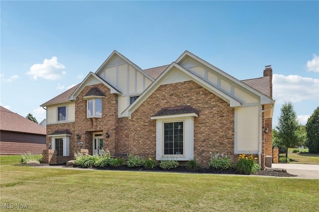 1101 Partridge Dr, Wadsworth, OH 44281 - view of front of house with a chimney, a front yard, board and batten siding, and brick siding