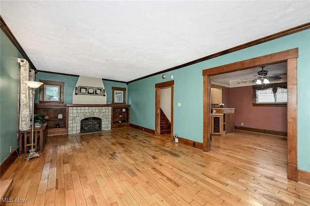 517 Broad Ave NW, Canton, OH 44708 - unfurnished living room featuring ornamental molding, wood-type flooring, a tile fireplace, healthy amount of natural light, and ceiling fan