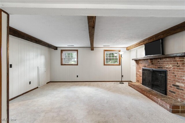 254 Eastern Rd, Doylestown, OH 44230 - unfurnished living room with light colored carpet, a brick fireplace, beamed ceiling, and wood walls