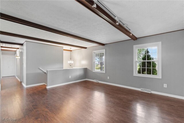254 Eastern Rd, Doylestown, OH 44230 - unfurnished room with wood finished floors, beamed ceiling, a textured ceiling, a chandelier, and rail lighting