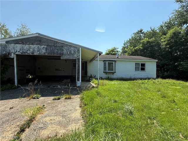 3066 State Route 7 N, Pierpont, OH 44082 - rear view of property with an attached garage, dirt driveway, and a yard