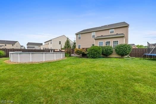 1932 Pinewood Ln, Painesville, OH 44077 - back of property with a trampoline and a fenced backyard
