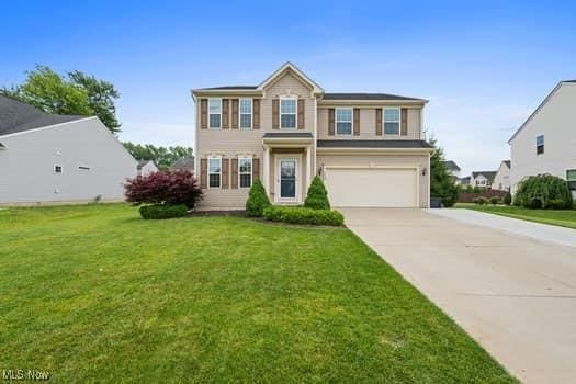 1932 Pinewood Ln, Painesville, OH 44077 - view of front facade with an attached garage, concrete driveway, and a front lawn