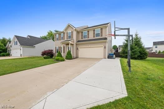 1932 Pinewood Ln, Painesville, OH 44077 - view of front of home with driveway, an attached garage, and a front yard
