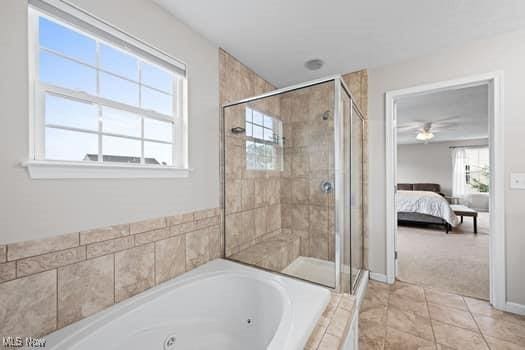 1932 Pinewood Ln, Painesville, OH 44077 - bathroom featuring a tub with jets, a stall shower, ensuite bathroom, and a ceiling fan