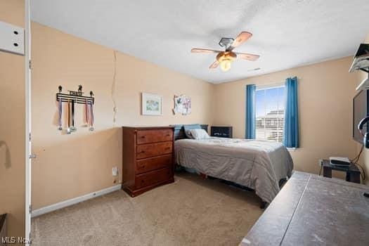 1932 Pinewood Ln, Painesville, OH 44077 - bedroom with light carpet and a ceiling fan