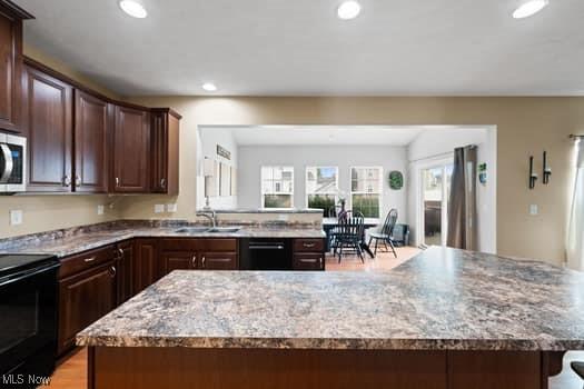 1932 Pinewood Ln, Painesville, OH 44077 - kitchen with black appliances, recessed lighting, light stone counters, and dark brown cabinetry