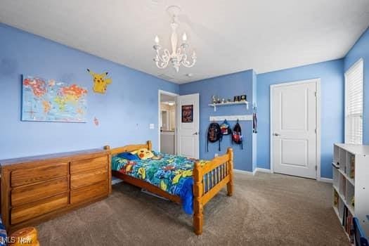 1932 Pinewood Ln, Painesville, OH 44077 - carpeted bedroom featuring a chandelier and baseboards