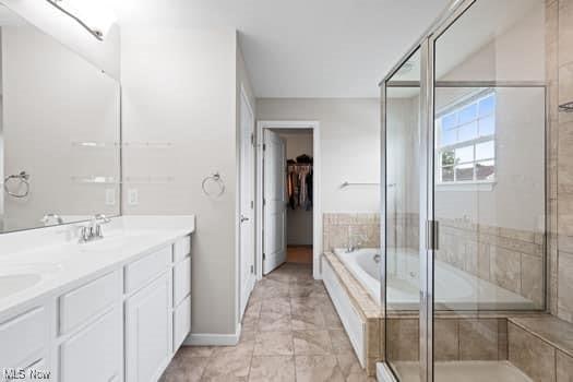1932 Pinewood Ln, Painesville, OH 44077 - bathroom with double vanity, a garden tub, a stall shower, and a spacious closet