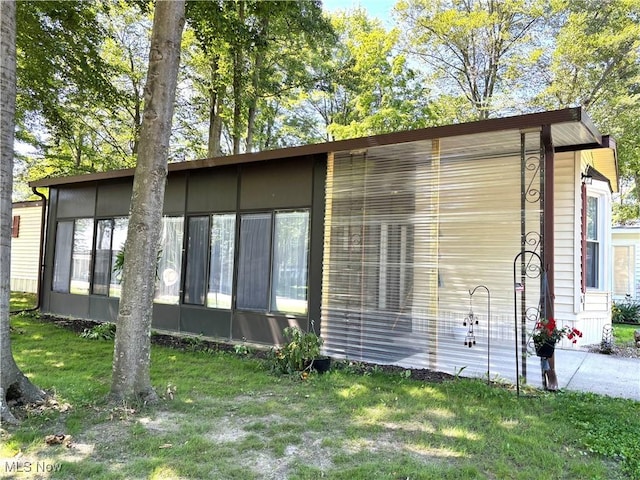 1229 Columbiana Lisbon Rd Unit 104, Columbiana, OH 44408 - view of home's exterior with a yard and a sunroom