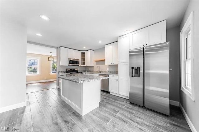 1348 W Erie Ave, Lorain, OH 44052 - kitchen featuring stainless steel appliances, light stone countertops, white cabinets, glass insert cabinets, and a center island