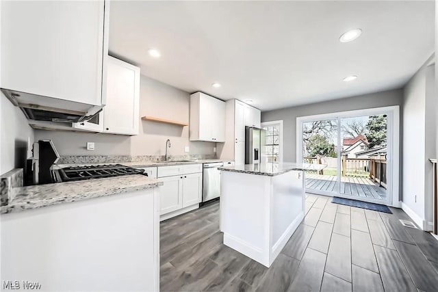 1348 W Erie Ave, Lorain, OH 44052 - kitchen featuring appliances with stainless steel finishes, a kitchen island, white cabinetry, light stone countertops, and open shelves