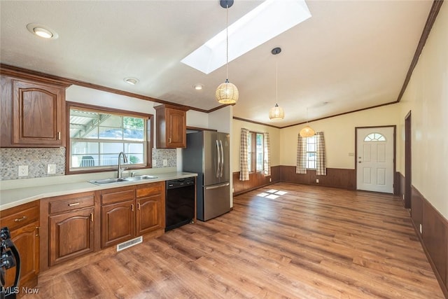 19 Pageant Ln, Olmsted Twp, OH 44138 - kitchen with black dishwasher, a skylight, crown molding, freestanding refrigerator, and light wood finished floors
