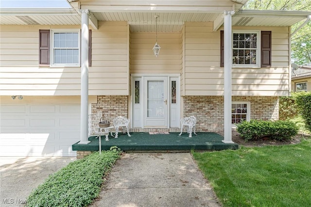 530 N Scranton St, Ravenna, OH 44266 - view of exterior entry with brick siding, a garage, and driveway