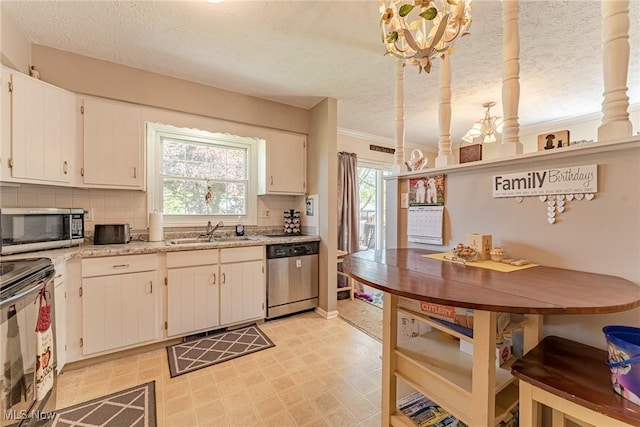530 N Scranton St, Ravenna, OH 44266 - kitchen with stainless steel appliances, a chandelier, backsplash, a textured ceiling, and white cabinetry