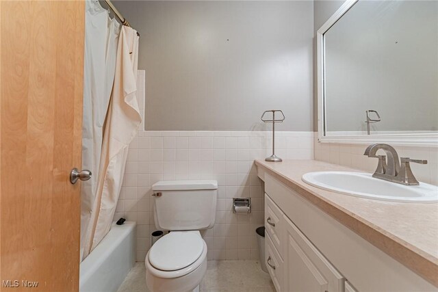 530 N Scranton St, Ravenna, OH 44266 - full bath with vanity, tile walls, shower / tub combo, a wainscoted wall, and tile patterned flooring