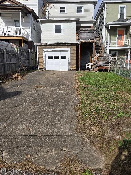 412 Concord St, Martins Ferry, OH 43935 - back of house featuring driveway, a garage, and stairway