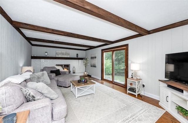 1593 Stonington Dr, Hudson, OH 44236 - living room featuring wood finished floors, beam ceiling, a brick fireplace, and a decorative wall