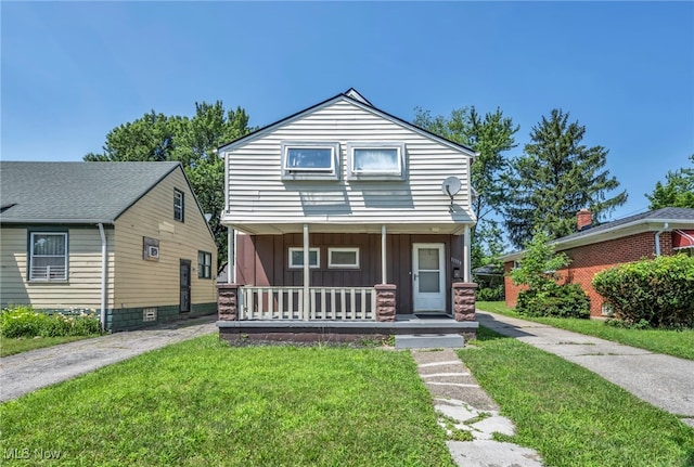 11113 Avon Ave, Cleveland, OH 44105 - view of front facade with board and batten siding, a porch, and a front yard