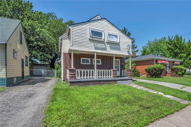 11113 Avon Ave, Cleveland, OH 44105 - view of front of house with board and batten siding, a porch, asphalt driveway, a front lawn, and a gate