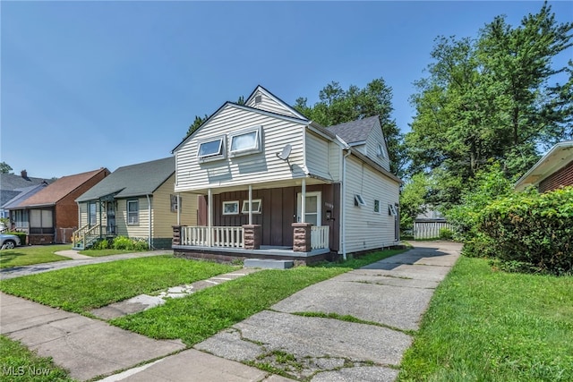 11113 Avon Ave, Cleveland, OH 44105 - view of front facade featuring board and batten siding, a porch, and a front yard