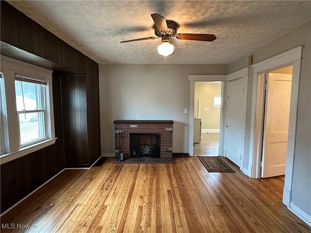 4011 E 29th St, Newburgh Heights, OH 44105 - unfurnished living room with hardwood / wood-style flooring, a ceiling fan, and a brick fireplace