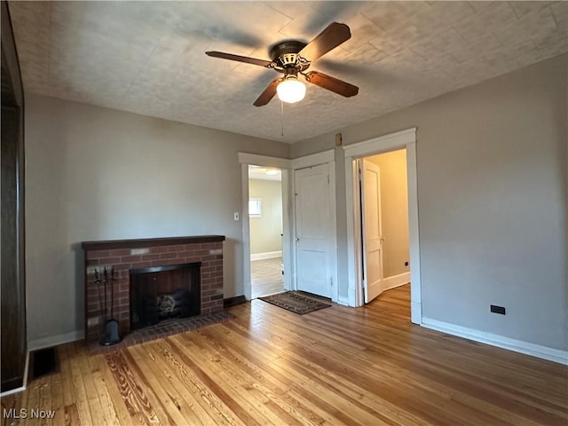 4011 E 29th St, Newburgh Heights, OH 44105 - unfurnished living room featuring a ceiling fan, wood-type flooring, and a fireplace