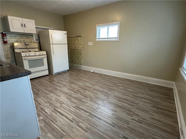 4011 E 29th St, Newburgh Heights, OH 44105 - kitchen with white appliances, dark countertops, and white cabinets