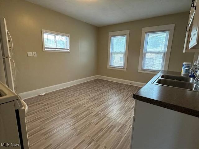 4011 E 29th St, Newburgh Heights, OH 44105 - kitchen featuring freestanding refrigerator, dark countertops, light wood finished floors, and stove