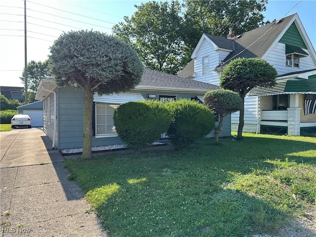 4013 E 29th St, Newburgh Heights, OH 44105 - view of front of house with a front yard, a detached garage, and an outbuilding