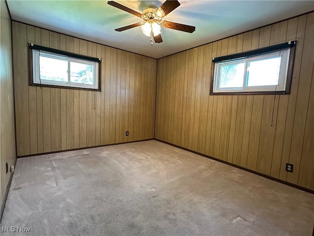 4013 E 29th St, Newburgh Heights, OH 44105 - unfurnished room featuring plenty of natural light, light colored carpet, ceiling fan, and wood walls