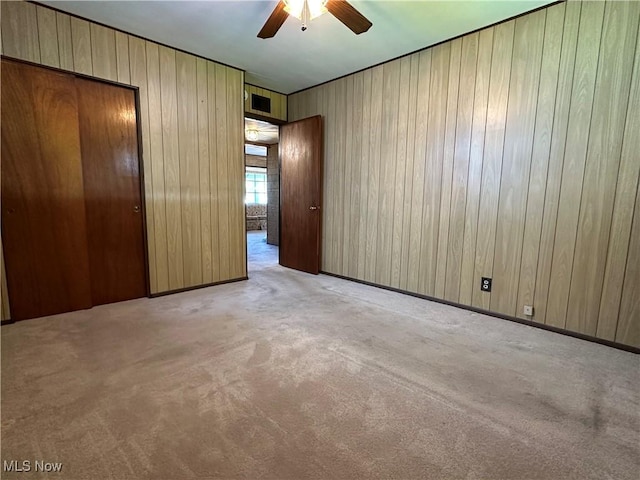 4013 E 29th St, Newburgh Heights, OH 44105 - unfurnished bedroom with carpet flooring, a closet, wood walls, and ceiling fan