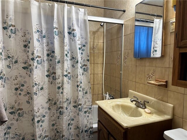 4013 E 29th St, Newburgh Heights, OH 44105 - bathroom with tile walls, vanity, and shower / bath combination with curtain